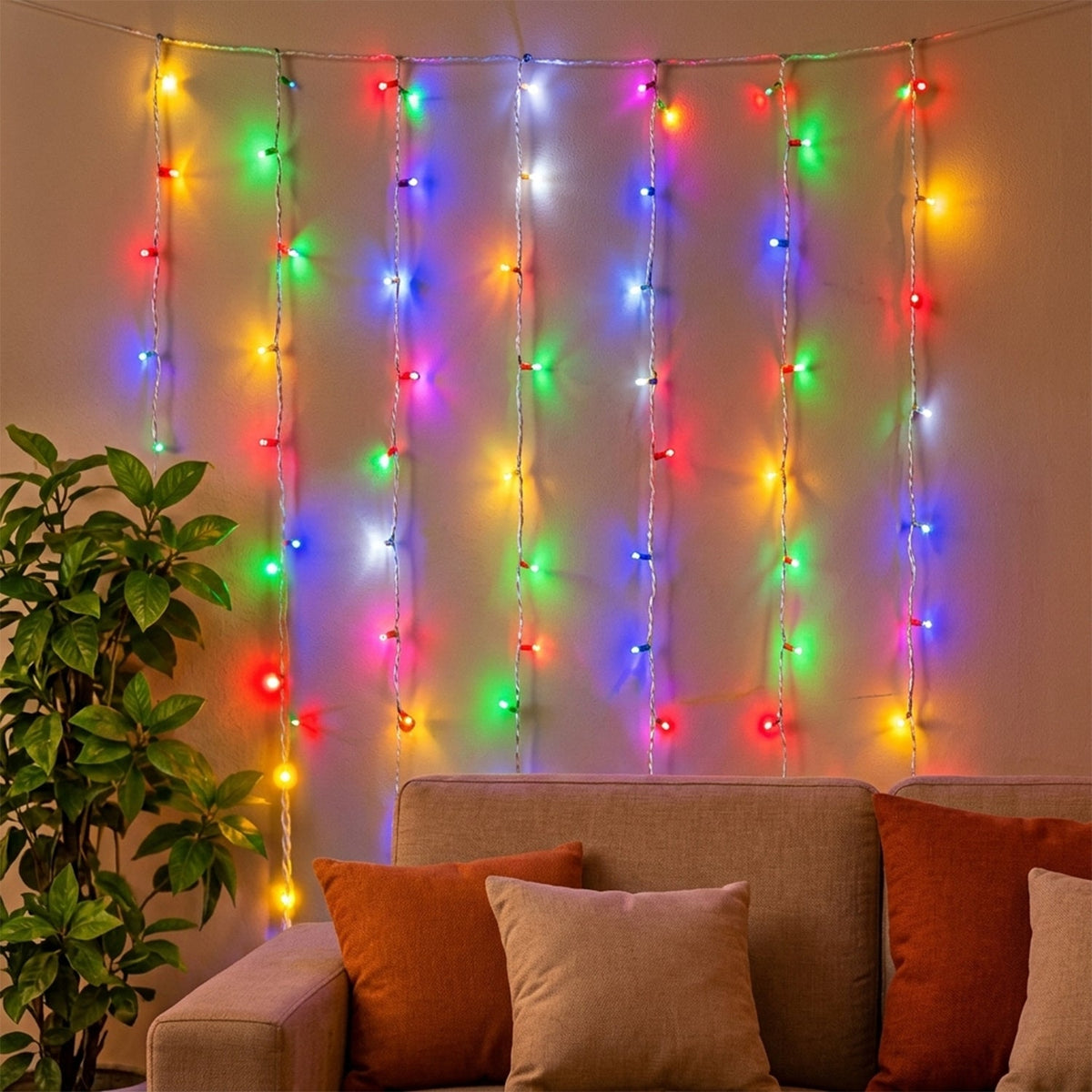 Multicolor LED curtain lights draped across a wall, casting a warm glow over a sofa with cushions.