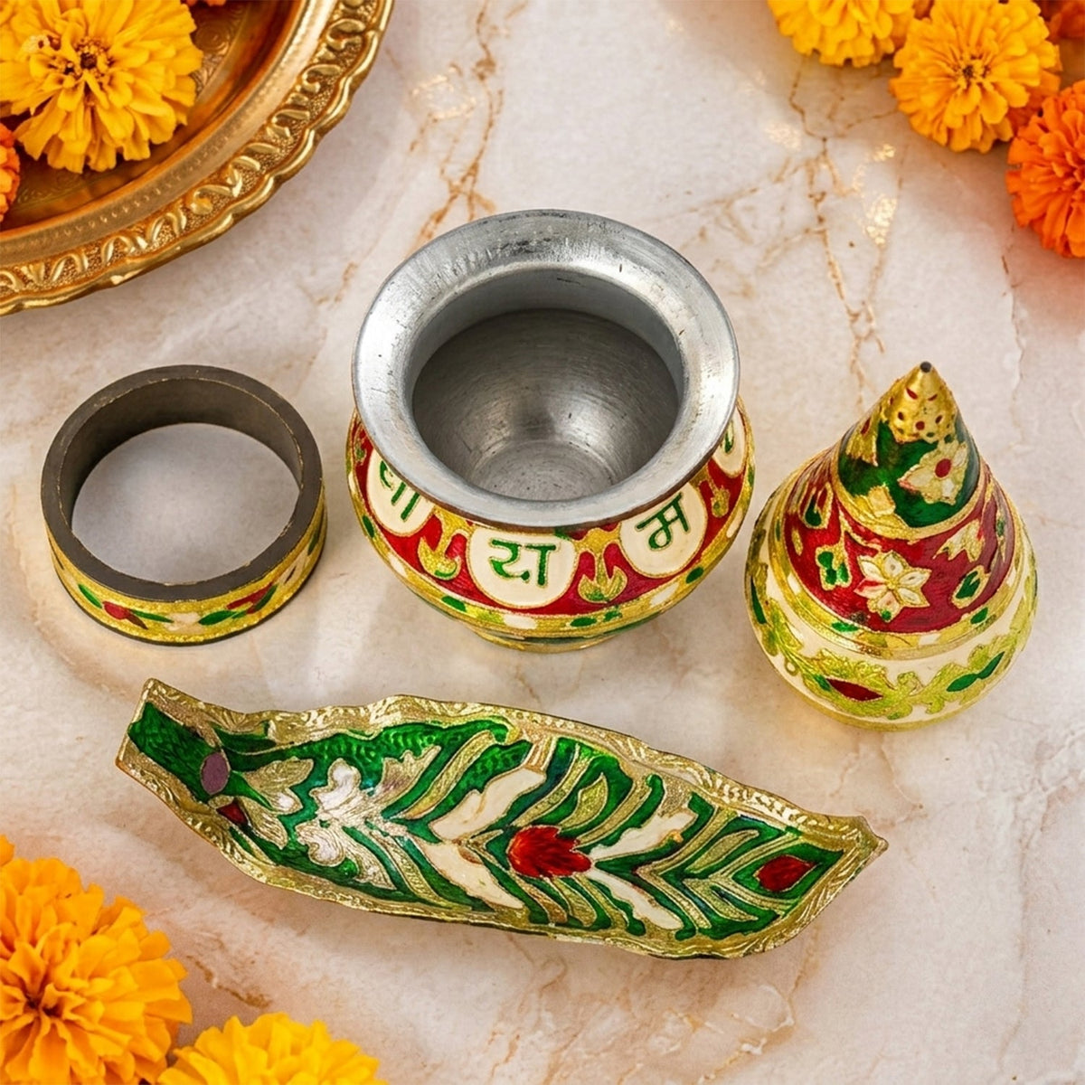 A four-piece kalash set, including a pot, base, conical top, and leaf tray, is displayed on a marble surface with marigolds.