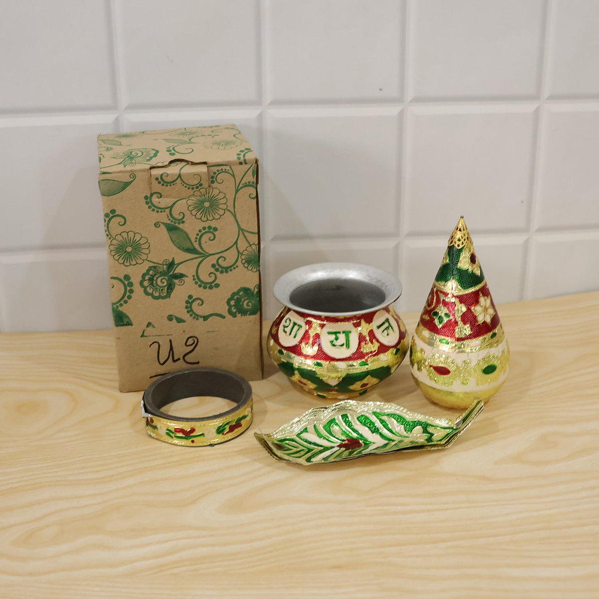 Decorative metal pooja kalash set in a home temple setting